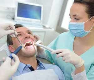 Patient opening his mouth & dentsist checking patients mouth 